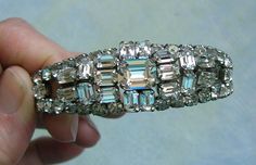 Vintage Austria Rhinestone Bracelet, 1950's Rhinestone Bracelet, Old Austria Rhinestone Bracelet  Beautiful 1950's Austria rhinestone bracelet.  This dazzling bracelet has clear square and round cut crystal rhinestones which are prong set in a silver tone setting.  The bracelet has an open bottom that allows it to give a little when you put it on your wrist.  The bracelet has a lot of sparkle to it.  The bracelet is marked "Austria" on the inside of the bracelet.  The bracelet measures 6 1/2" lo Rhinestone Bracelet, Clear Rhinestones, Crystal Rhinestone, Prong Setting, Austria, Halloween Shopping, Round Cut, Labour Day, Silver Tone