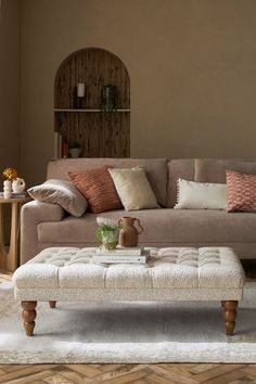 a living room with a couch, coffee table and rug on the floor in front of it