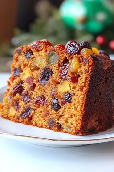 a piece of cake sitting on top of a white plate next to a christmas tree