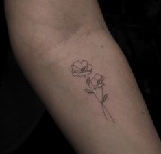 a single flower tattoo on the left arm