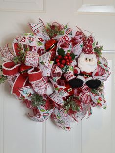 a christmas wreath on the front door with a santa clause and candy canes attached to it