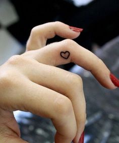 a woman's hand with a heart tattoo on it