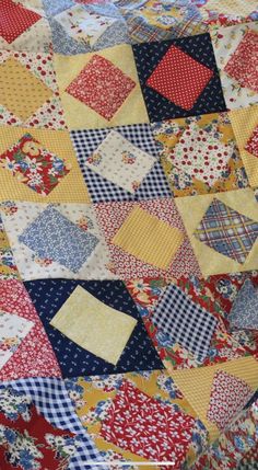 an old quilt with many different colors and patterns on it's edges, including red, yellow, blue, and white