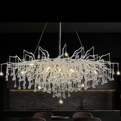 a modern chandelier hanging over a dining room table