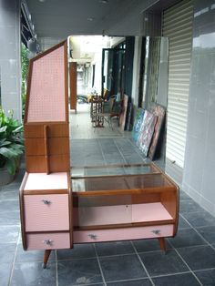 a pink dresser sitting on top of a tiled floor