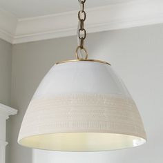 a light fixture hanging from a ceiling in a room with white walls and trimmings