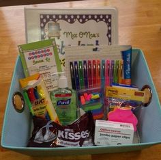 a blue basket filled with school supplies on top of a wooden table