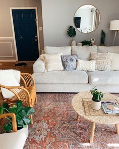 a living room filled with furniture and a mirror on the wall above it's door