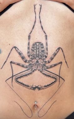 a close up of a person's stomach with a spider tattoo on it