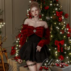 a woman in a red and black dress next to a christmas tree