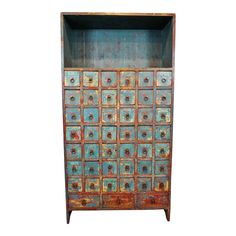 an old wooden cabinet with many drawers and knobs on the doors is painted blue