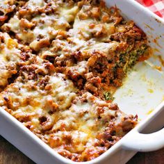 a casserole dish with meat, cheese and sauce in it on a table