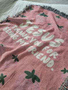 a pink blanket with green leaves on it