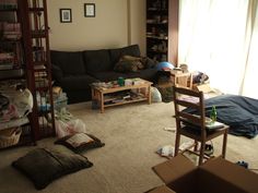 the living room is cluttered with boxes, books and other things to do in it