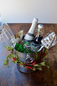 a silver pot filled with lots of wine and other items on top of a wooden table