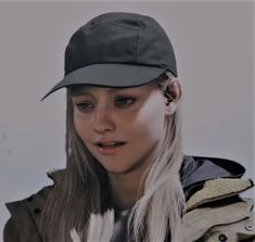 a woman with long hair wearing a hat and looking at the camera while standing in front of a white background