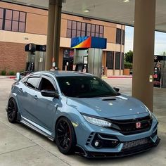 a blue car parked in front of a gas station