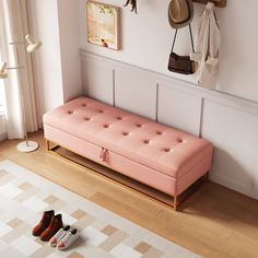 a pink bench sitting on top of a hard wood floor next to a white rug