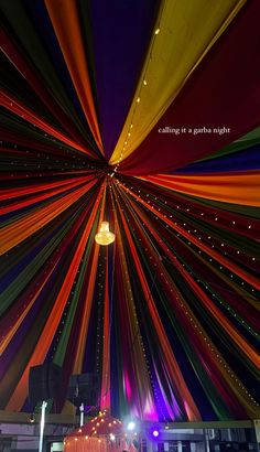 the ceiling is decorated with multicolored lights and streamers in an open space