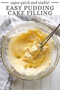 a glass bowl filled with batter on top of a white table next to a blue towel