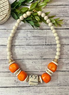 This gorgeous bright orange bone bead necklace is THE statement orange necklace.  Made with African bone beads and 12mm white wood beads, it measures approximately 21 inches in total length, and has a lobster clasp closure. An awesome true orange for game day too.  These natural beads are all unique! Yours will look very similar but there can be slight differences in shape and markings. It's what makes these bone beads unique!  Thanks for stopping by Beaded Blues!