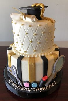 a graduation cake decorated with white and gold icing