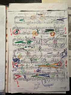 an open book with music notes and writing on the pages in different colors, shapes and sizes