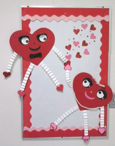 two paper hearts are hanging on the wall with one holding another's hand and heart shaped