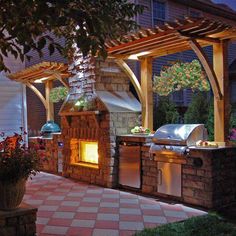 an outdoor kitchen with grill and bbq at night