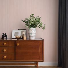 a wooden dresser topped with a vase filled with flowers