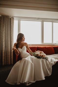 a woman in a wedding dress sitting on a couch