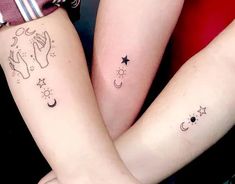 two people holding hands with tattoos on their arms and one has a star, moon and crescent