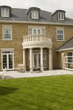 a large brick house with a circular patio and lawn area in front of the house