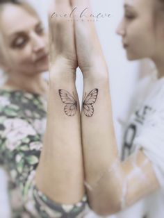 two women with tattoos on their arms and one has a butterfly tattoo on her arm