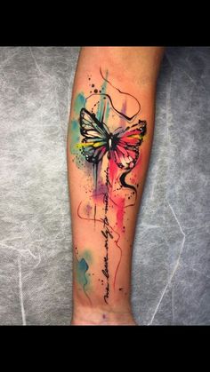 a woman's leg with a colorful butterfly tattoo on the left side of her arm