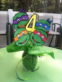 a green vase filled with water sitting on top of a table next to a number four sign