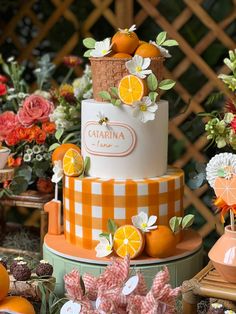 an orange and white tiered cake with flowers on the top is surrounded by other decorations