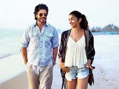 a man and woman walking on the beach