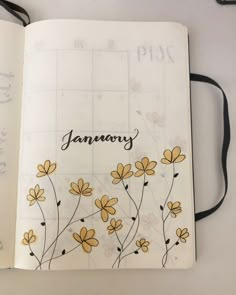 an open planner with yellow flowers and the word january written in black ink on it