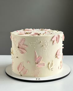 there is a white cake with pink flowers on it