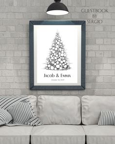 a christmas tree is hanging on the wall in front of a white couch with striped pillows