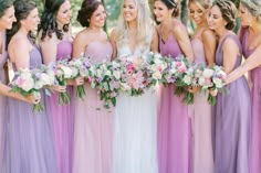 a group of women standing next to each other holding bouquets