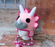 a crocheted pink and white giraffe hat on a mannequin head