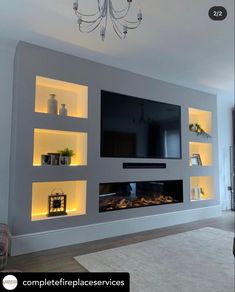 modern living room with built - in entertainment center, fireplace and chandelier lighting