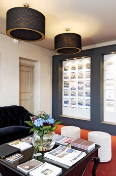 a living room filled with furniture next to two large windows covered in shades of blue and orange