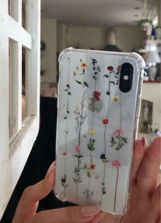 someone is holding up their phone case with flowers on it