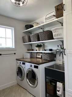 a washer and dryer in a laundry room with baskets on the shelves above