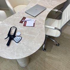 a table with scissors, notepads and a laptop on it in an office setting