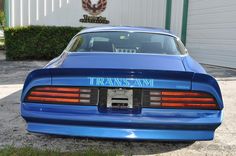 a blue sports car parked in front of a building with the words transs am on it