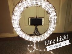 a round light up mirror with a cell phone on it's stand in front of a door